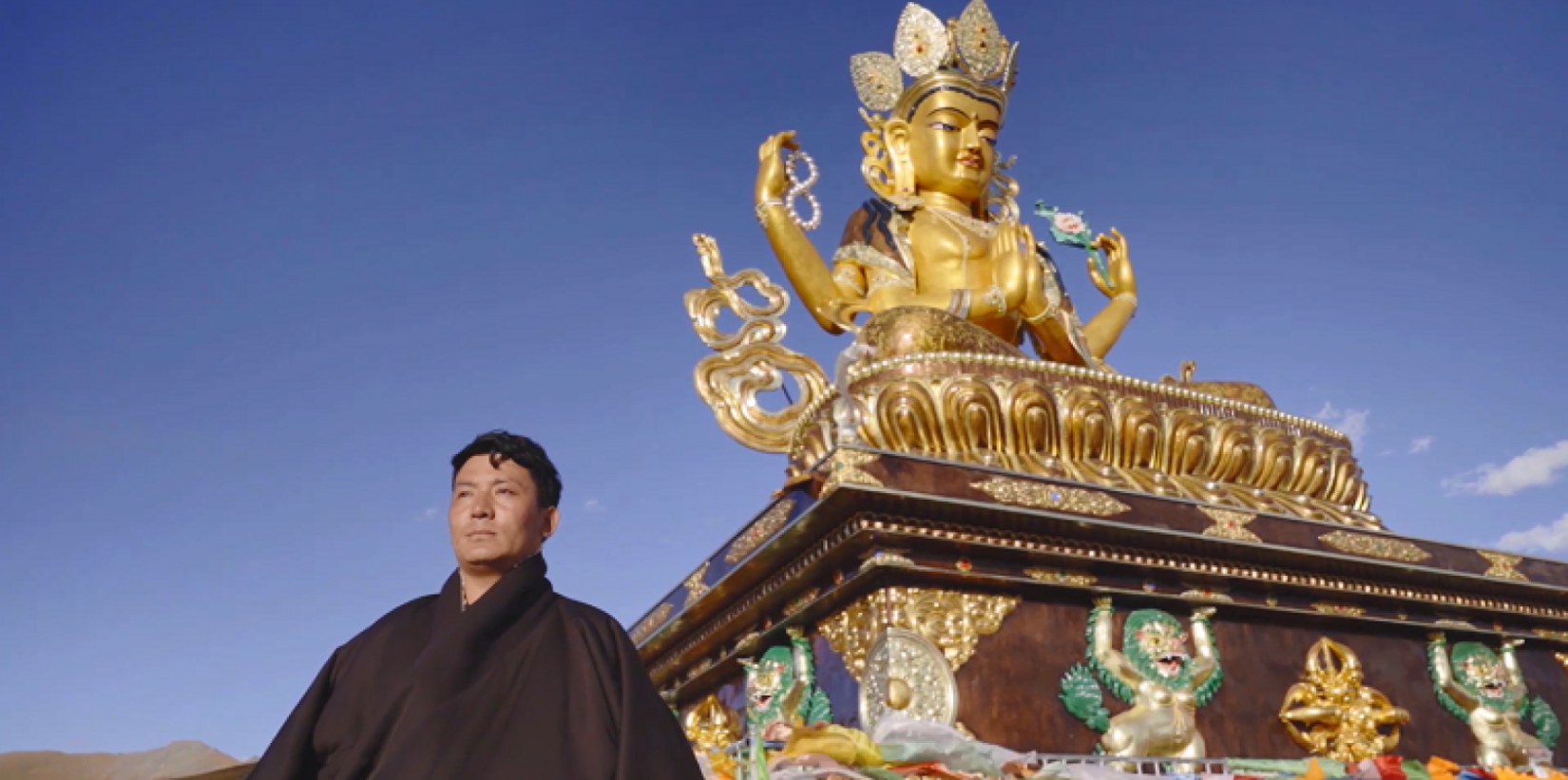Ban Jiu standing in front of a Tibetan Buddhist stupa.