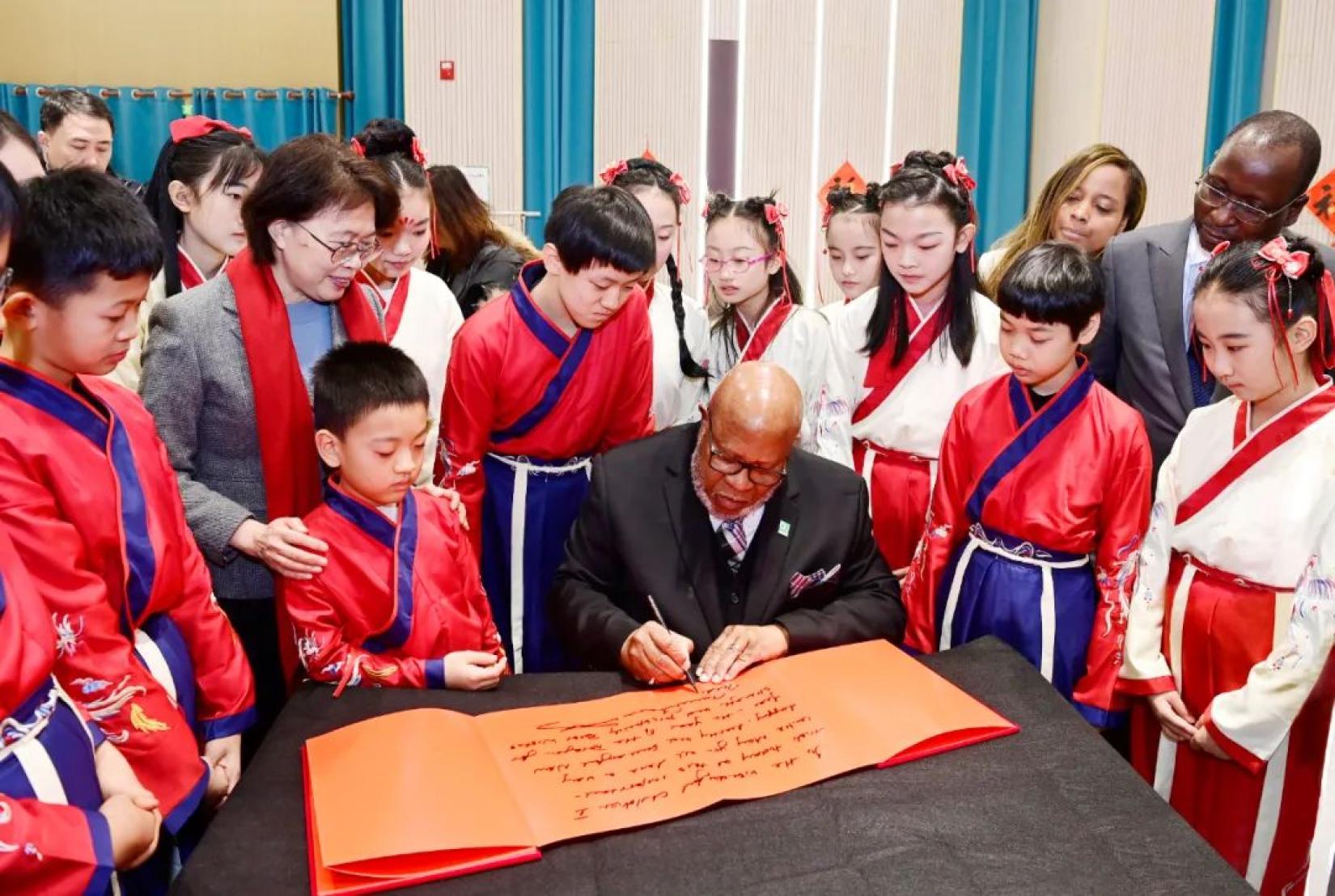 Mr. Dennis Francis, President of the UN General Assembly, writes a message of blessing at the National Children’s Center in Beijing