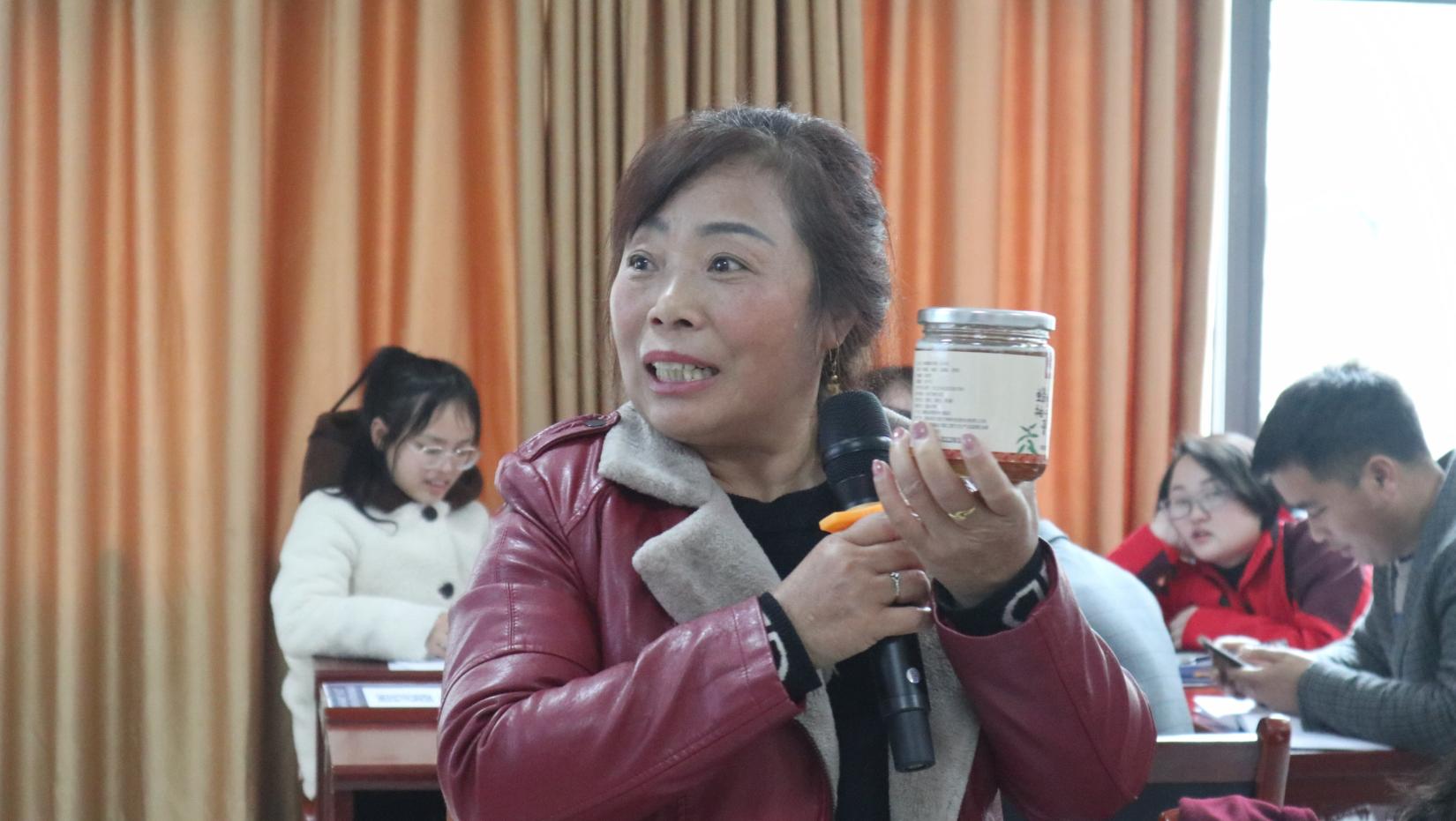 Yuan'ai presents a product she helped to market at a Women Up training in Fenghuang.