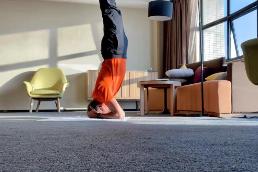 The author Siddharth Chatterjee doing a headstand in his hotel room. 