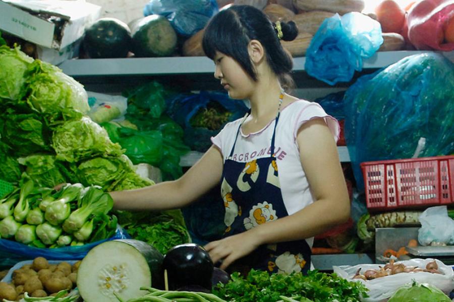 A woman sells fresh produce at her market stall in Beijing, China.