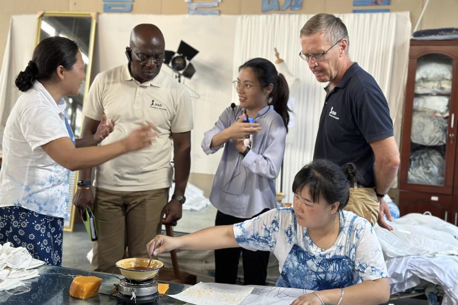 A member of the Lanyin Cooperative shows me how to dye traditional batik textiles at workshop.