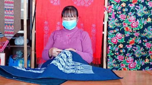 A Yi woman demonstrates traditional Yi embroidery.